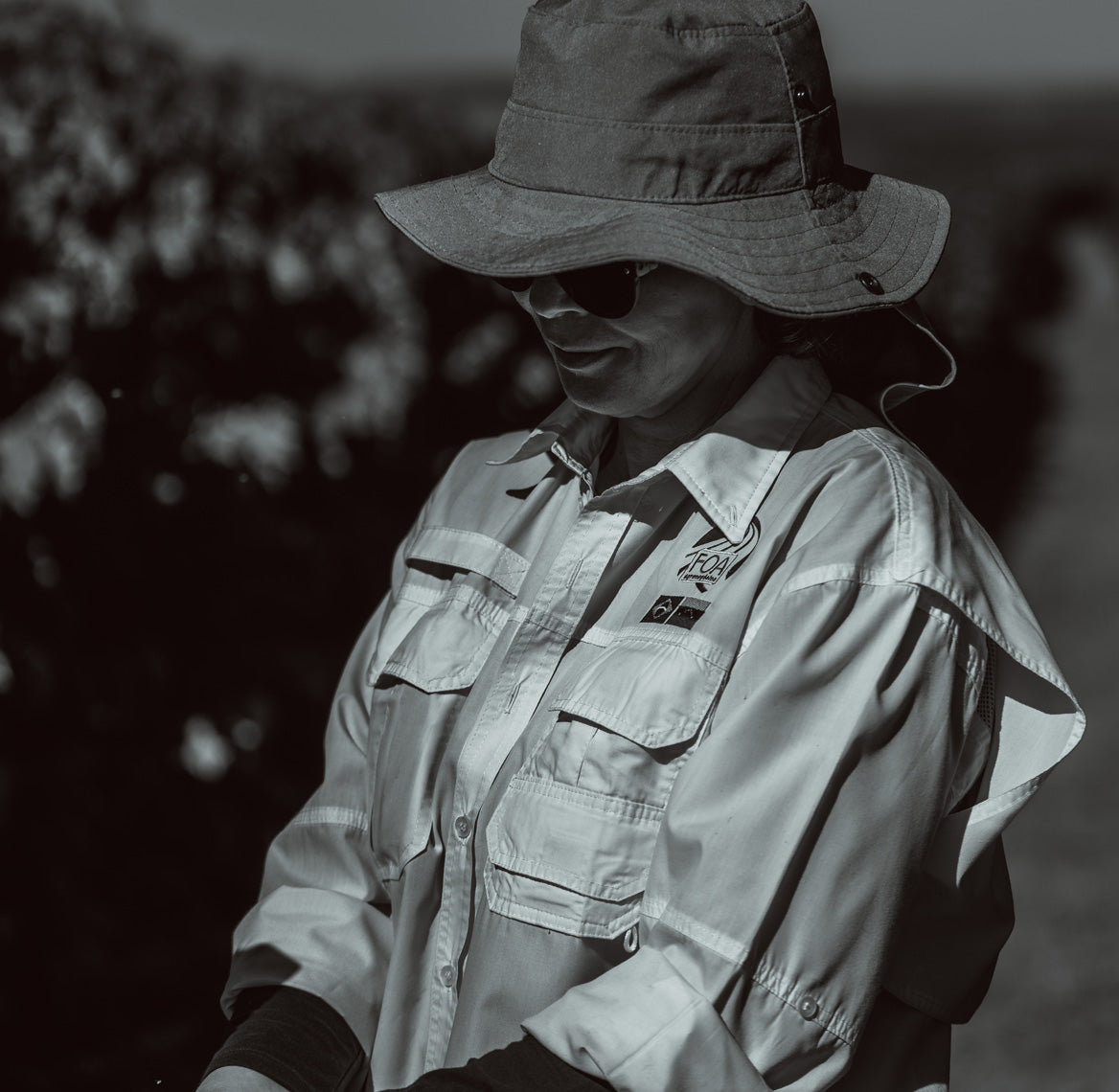 Person wearing a wide-brimmed hat and light shirt outdoors